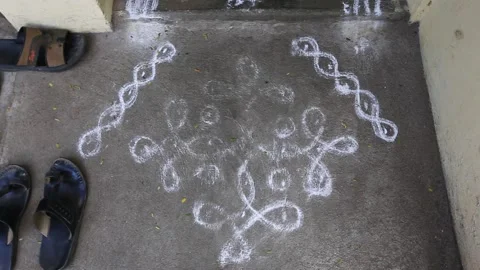 Worn out rangoli in front of a household front door with shoes on the side Stock Footage 143299171