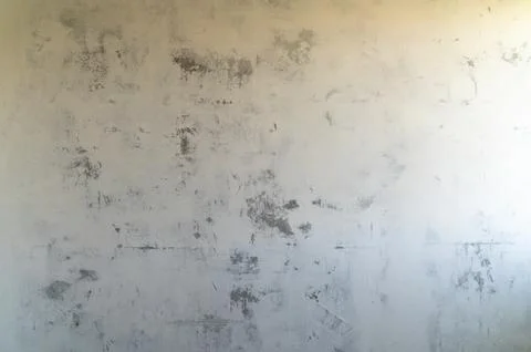 Worn plaster wall with subtle stains and uneven texture Stockfoto's