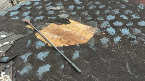 Worn roofing membrane with exposed wood and loose debris viewed during roof Stock Footage 346757006