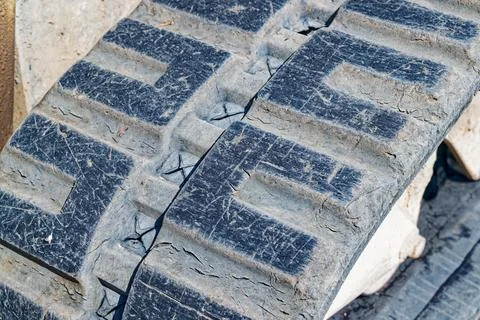Worn rubber tracks of heavy construction machinery covered in dirt and scra.. Stock Photos