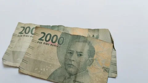 Worn rupiah banknotes on a white background Видео 313815140