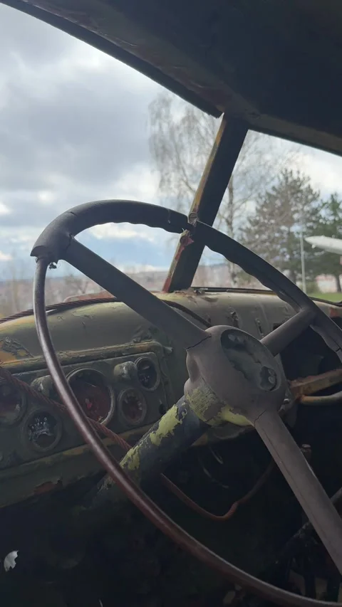 Worn steering wheel inside abandoned Soviet military truck cab Cold War Stock Footage 333488545