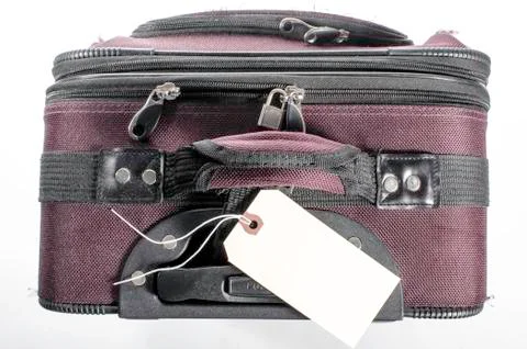 Worn suitcase with tag Stock Photos
