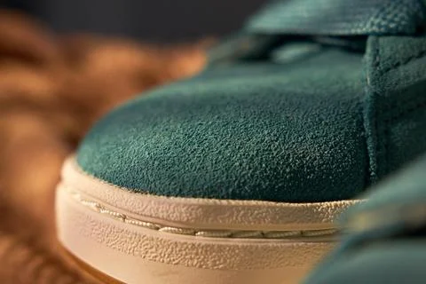 Worn teal sneaker toe captured in urban night scene, soft bokeh, asphalt text Stock Photos