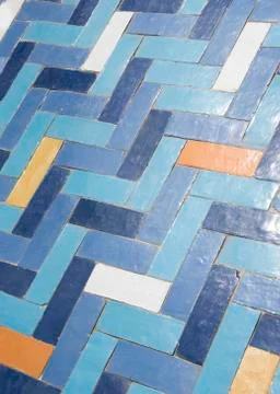 Worn  tiled floor in Herringbone pattern, in blue, orange, and white Stock Photos