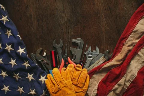 Worn work gloves on tools with US American flag. Made in USA, American work.. Stock Photos