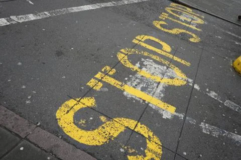 Worn Yellow 'Stop' Road Markings On Asphalt In Nottingham, England Street. Stock Photos