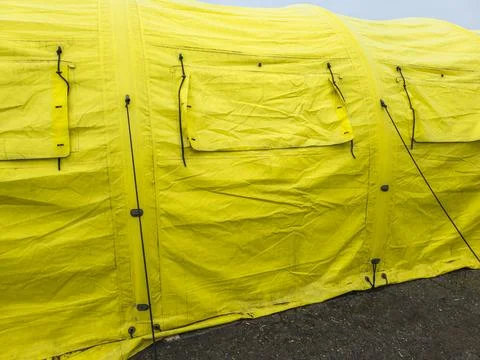 Worn yellow tarp with closed window covers at overcast day, full-frame close Stock Photos
