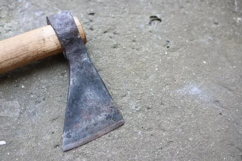 The wornout axe head rests on aged concrete, revealing its weathered look and 스톡 사진
