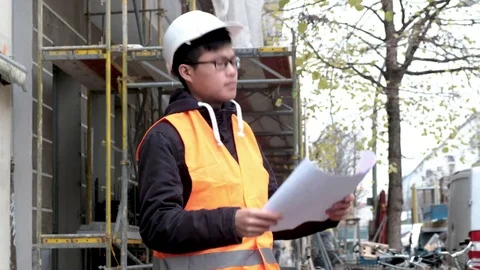 Worried and tired Asian apprentice engineer snorting on construction site Stock Footage 82657145