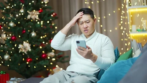 Worried asian man read bad news message notification on new year christmas eve  Stock Footage 219912600