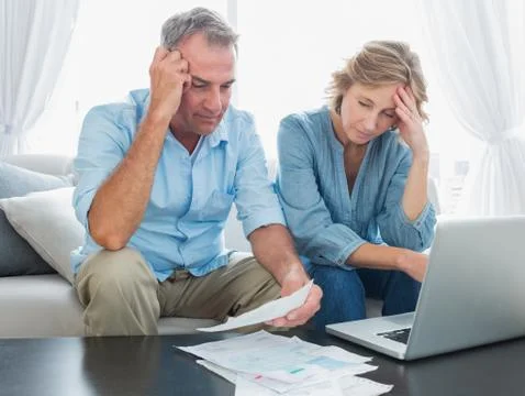 Worried couple paying their bills online with laptop Stock Photos