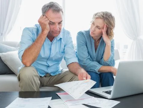 Worried couple using their laptop to pay their bills Stock Photos