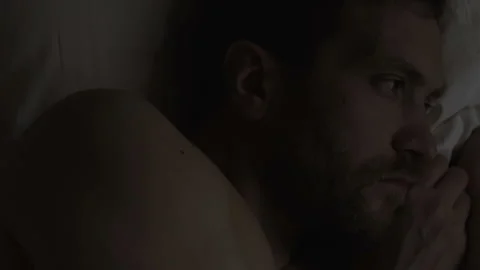 Worried handsome man lying in bed suffering insomnia, sleep disorder, problems Stock Footage 86777392