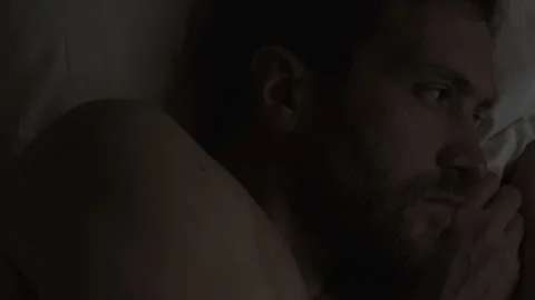 Worried handsome man lying in bed suffering insomnia, sleep disorder, problems Stock Footage 87188949