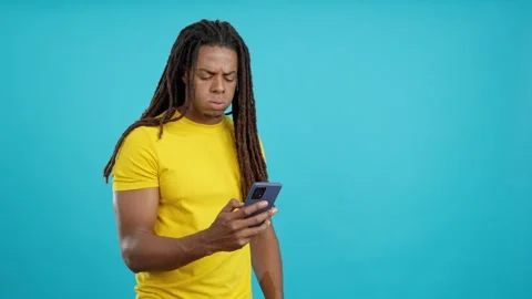 Worried latin man with dreadlocks using a mobile phone Stock Footage 243547977