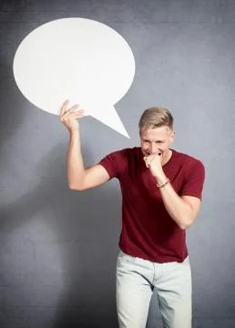 Worried man biting his hand while holding blank speech bubble. Stock Photos