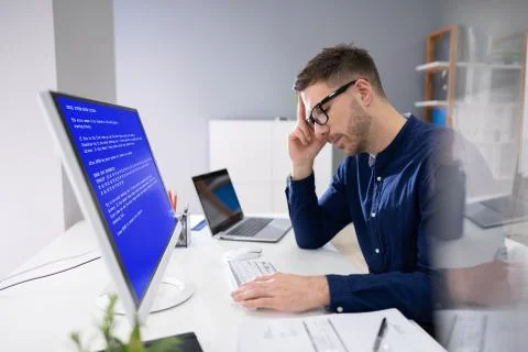 Worried Man At Computer With System Failure On The Screen Stock Photos