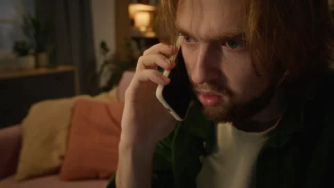 Worried Man Having Serious Conversation on Smartphone at Home Stock Footage 344865597