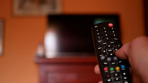 Worried man in self isolation switching between news channels on television Stock Footage 127287251