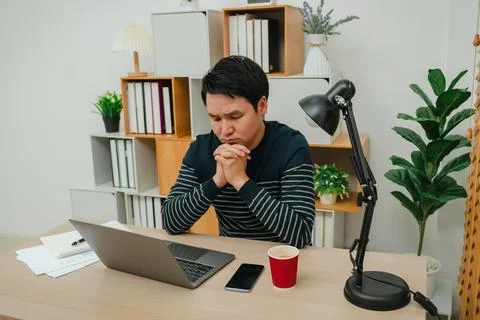Worried man working with laptop computer at home office Stock Photos