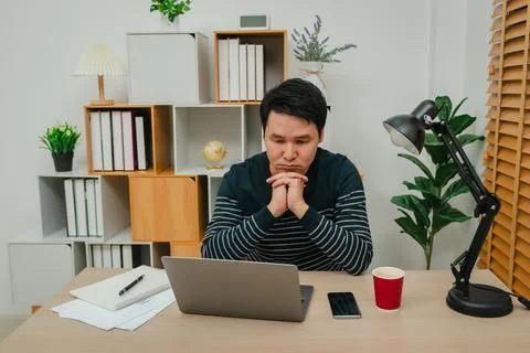 Worried man working with laptop computer at home office Stock Photos