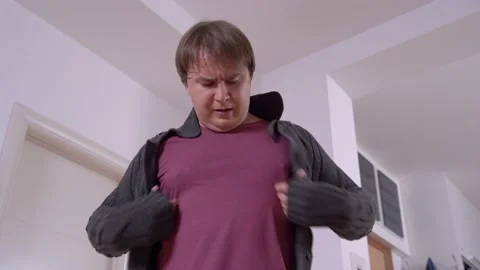 Worried plump man tries to button jacket in living room 스톡 동영상 149760284