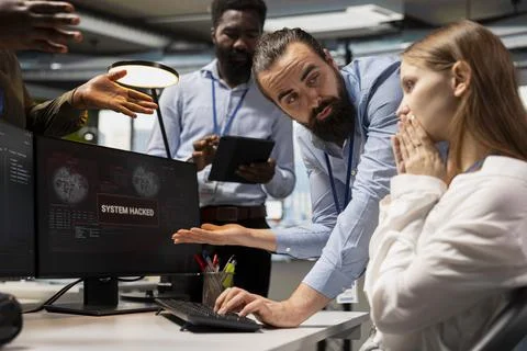 Worried team of programmers responding to hacking alert warning on screen Stock-Fotos