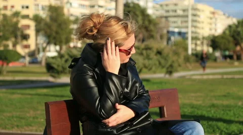 Worried woman sitting on a park bench Stock Footage 59019184
