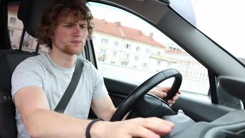 Worried young driver struggles to start a broken car during a city trip Stock Footage 343720744