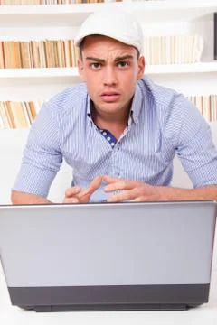 Worried young man having problems with laptop computer Foto stock