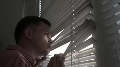 Worried Young Man Quickly Go to Blinds and Looks Through Them. Stockbeeldmateriaal 138807640
