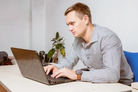 Worry businessman using laptop while sitting in office. Worker typing email o Stock Photos