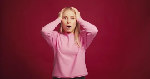 Worry, sad blonde middle aged woman holding head with open mouth looking at Stock Footage 321550371