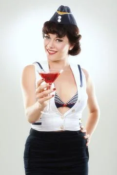 Would you like a sip. A gorgeous pin up sailor girl offering the viewer a sip of Stock Photos