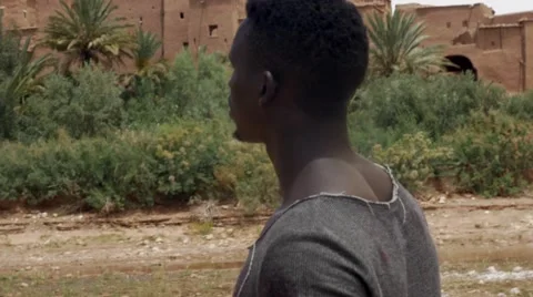Wounded black guy looks around at the sand house of Morocco 04 Video stock 67557541