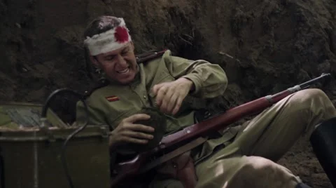 Wounded Soviet soldier during combat runs to portable radio, sits and drinks. Stock Footage 65954676