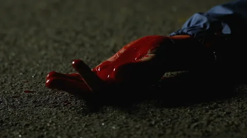 Wounded victim of murderer lying on ground, cruel crime in night street 库存影片 95859675