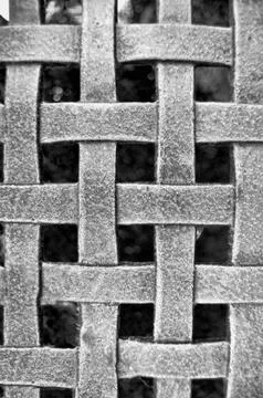 Woven metal mesh grid pattern on a black background Stock Photos