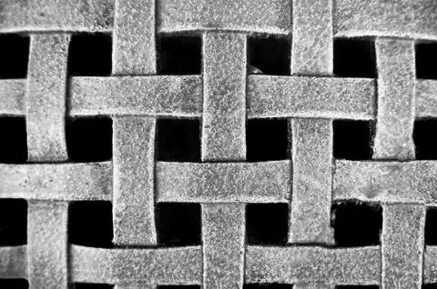 Woven metal mesh grid pattern on a black background Stock Photos