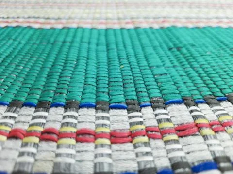 Woven plastic mat texture with vibrant multicolored striped woven patterns Fotos Stock