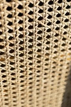 Woven rattan cane webbing texture on vintage furniture in warm light Fotos de archivo