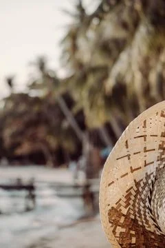 Woven straw hat close up on a blurred tropical beach background Stock Photos