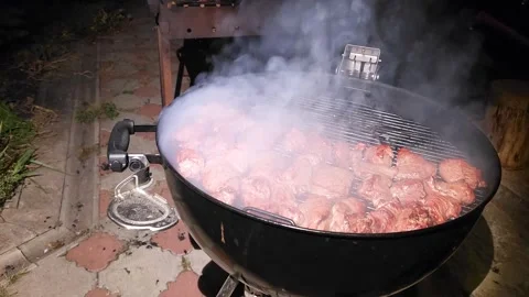 The wow effect is the smoke from under the lid of the charcoal grill Stock Footage 298024272