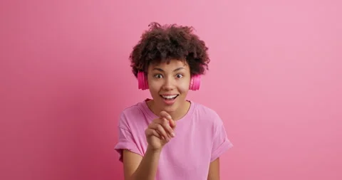 Wow how icredible it is. Impressed curly haired young woman indicates in front Stock Footage 150297763