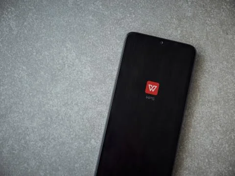 WPS Office app launch screen with logo on the display of a black mobile smart Stock Photos