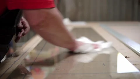 Wrap a white rag of a large piece of glass lying on the table. Preparation of Stock Footage 201821260