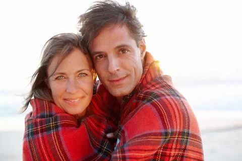 Wrapped up in affection. A devoted and affectionate couple wrapped in a blanket Stock Photos