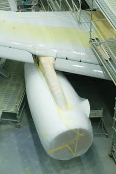 Wrapped airplane wing and engine are displayed in a maintenance area, surroun 写真素材