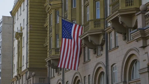 Wrapped around flagpole flag of the USA in Russia Moscow. Stock Footage 128923268